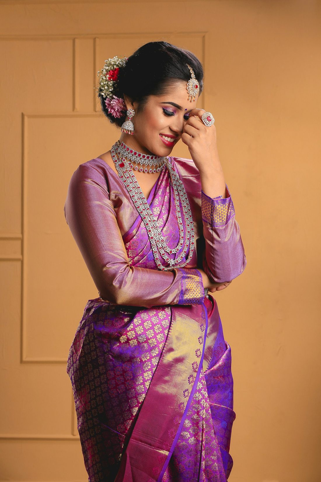 Purple Kanchipuram silk saree with heavy gold zari border and layered gold jewellery
