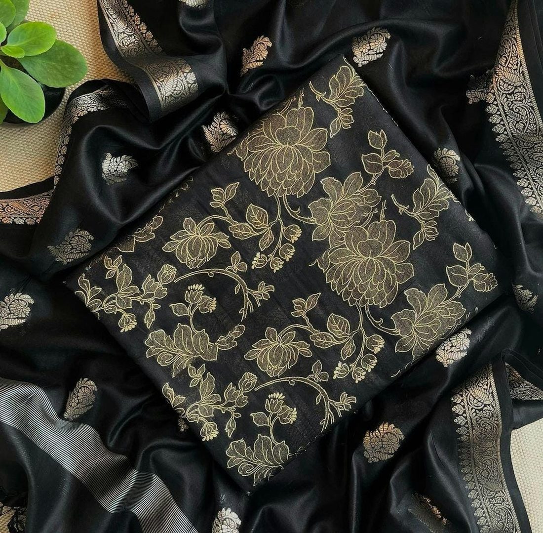 Black silk saree with a gold floral brocade pattern, folded flat