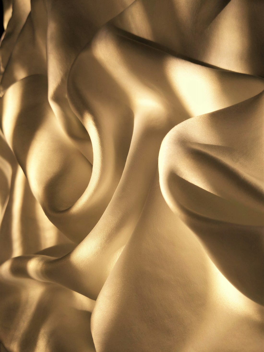Soft folds of champagne-coloured silk catching the light