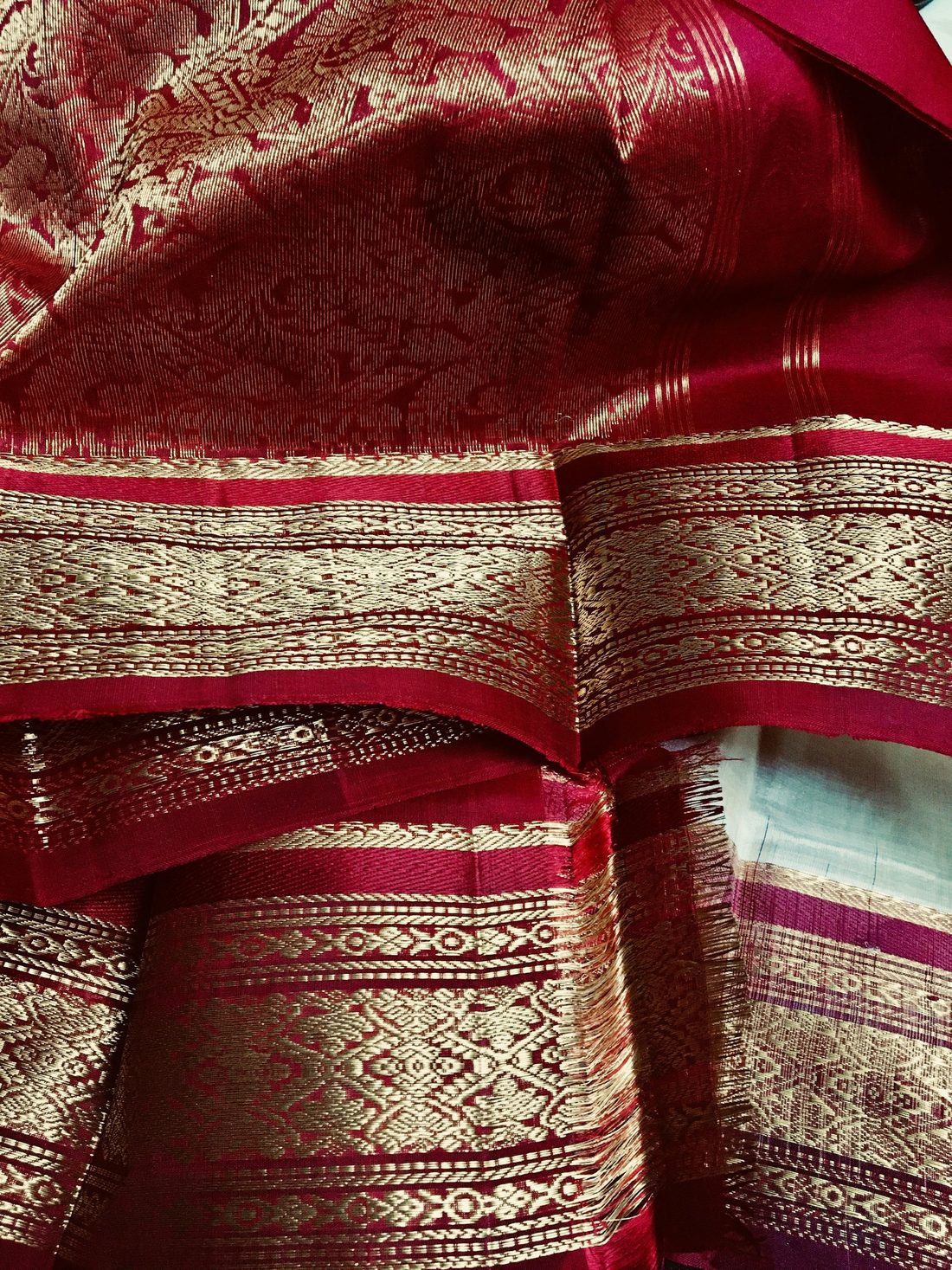 Close-up of a maroon silk saree border woven with dense gold zari